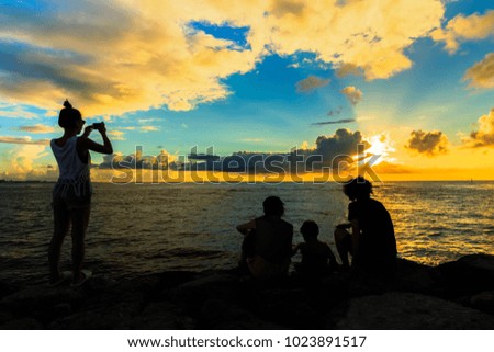 woman take picture sunset and beautiful blue sea at sunset beach Okinawa landmark Japan