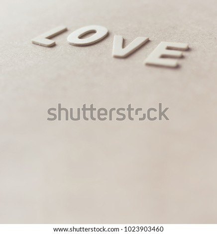 Valentine's day card with "LOVE" text  on wooden background.Extreme close up and abstraction with selective focus and very shallow dept of field composition,sweet pastel color toned.