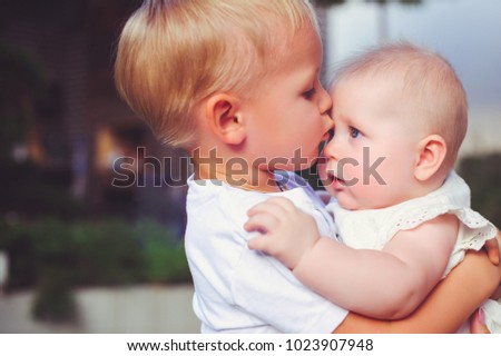 happy little brother playing hugs his sister baby, boy and girl embraces kisses, concept love and parenting. Royalty-Free Stock Photo #1023907948