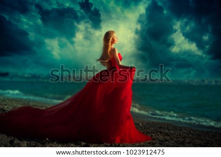 A woman in a red dress on the beach. Maritime vacation. Journey to the sea
