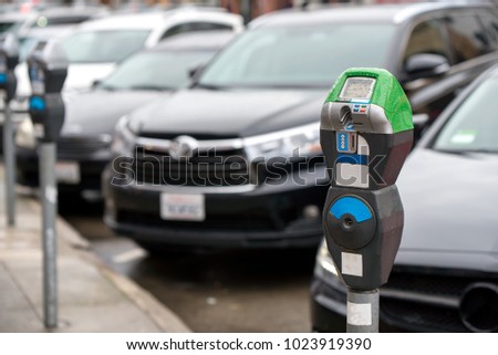 Parking machine with electronic payment in the city streets and a row of cars Royalty-Free Stock Photo #1023919390