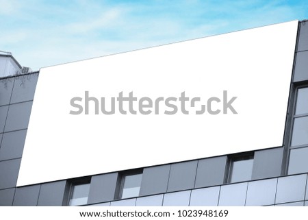 Blank advertising board on city building outdoors