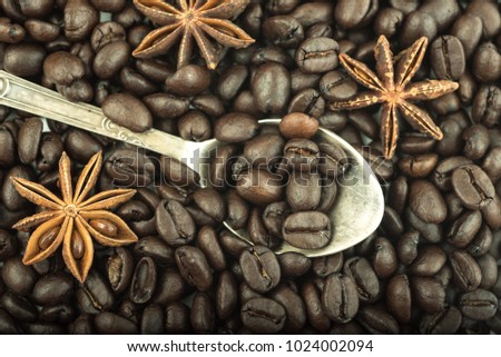 Old antique silver spoon, roasted coffee beans, anise seeds. Top View. Close up.