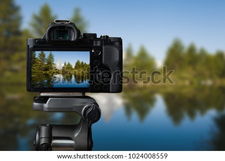 Camera on a tridop takes a picture of a mountain landscape