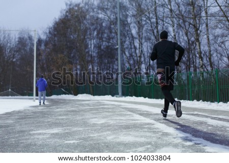 Photo of running sports man in stadium on background of trees