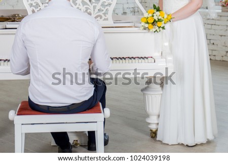 the bride and groom sit near the piano