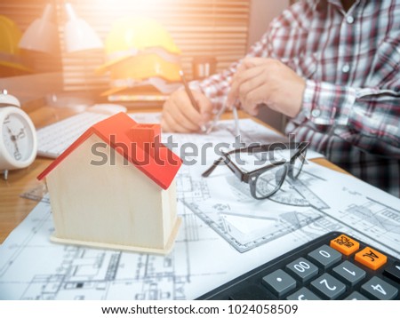 Picture of handsome male engineer,architect man working with computer and blueprints documents on desk inspection in workplace for architectural plan,sketching a construction project,selective focus.