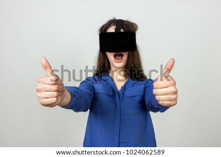 Girl in the helmet of virtual reality over gray background