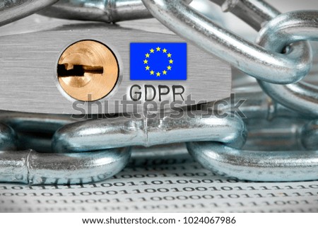 Macro photo of padlock and data on the paper with EU flag and GDPR letters imprinted on metal surface