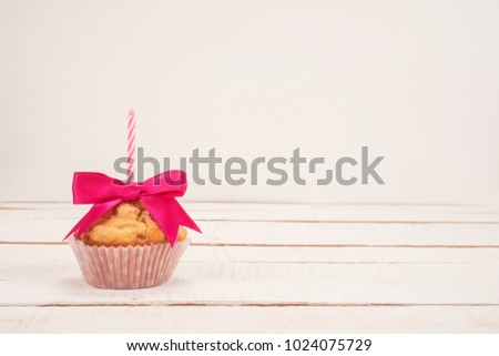 Birthday cupcake with candle on a white background