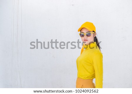 Portrait of beautiful asian woman in yellow cloths on dirty white wall,Hipsters girl wear yellow hat  take a picture,Thailand people