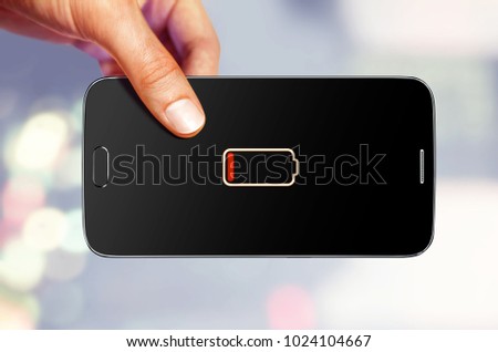 man holds mobile device which shows on the screen that a battery is low