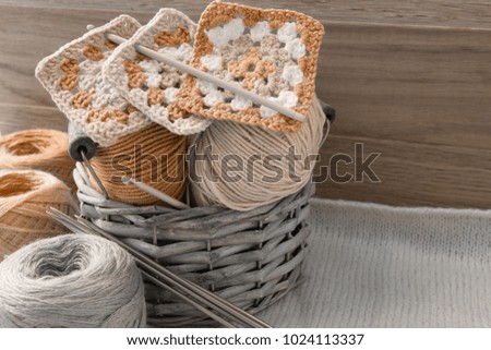 Balls of woolen threads and knitting needles. Scandinavian style. Threads for knitting in a basket. Image in sepia tones.