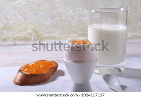 Morning Breakfast set with egg, orange jam on bread toast and milk in glass.