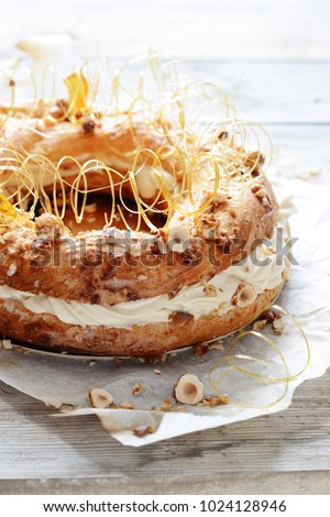 Cake Paris-Brest from the custard batter with air custard, praline and nuts in caramel. French dessert. Pastry.