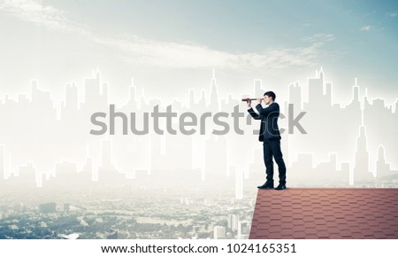 Young businessman in suit on roof edge. Mixed media