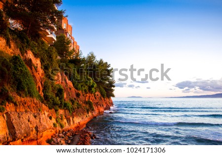 Background of a mountain cliff lit by the setting sun against the sea