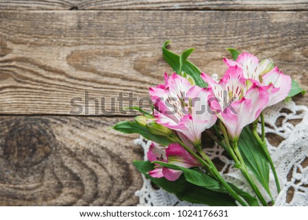 bouquet of pink flowers of Alstroemeria lies on a wooden background
