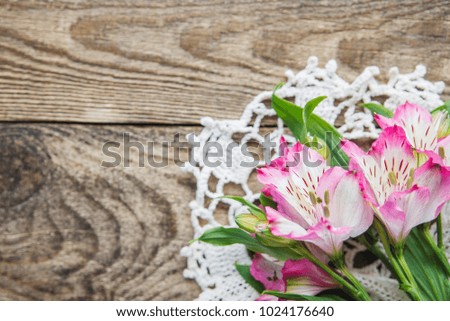 bouquet of pink flowers of Alstroemeria lies on a wooden background