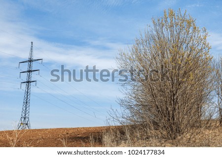 Spring landscape. energy pillars on the spring field. hilly terrain. trees without leaves. . The last snow.