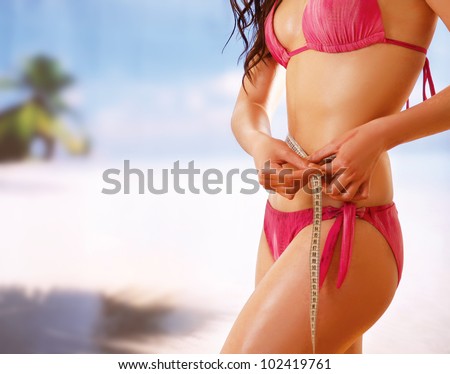 Unknown girl in bikini with tape-measure at sea