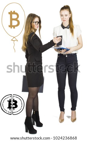 Beautiful women standing over white background with bitcoin sketches and talking. Virtual money concept. Cryptocurrency