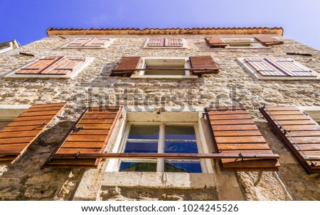 Old building in the old city in Budva, Montenegro. Nice wooden windows in the stone. Royalty-Free Stock Photo #1024245526