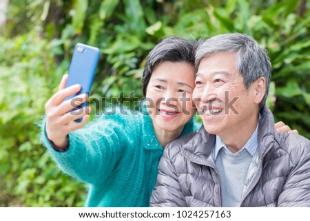 old couple selfie happily in the park
