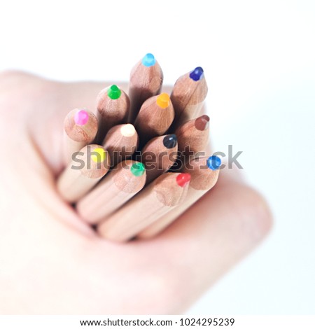 Hand holding wooden color pencils