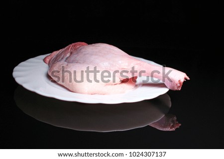 Chicken drumstick meat leg raw food on black reflective studio background. Isolated black shiny mirror mirrored background for every concept.