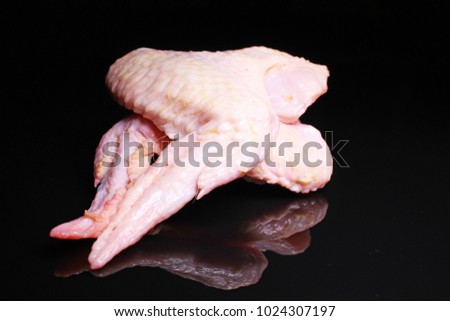 Chicken wings. Raw wing on black reflective studio background. Isolated black shiny mirror mirrored background for every concept.