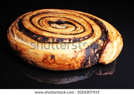 Chocolate pastry swirl on black reflective studio background. Isolated black shiny mirror mirrored background for every concept.