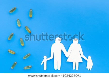 Prevention of diseases. Medicine for family health. Color pills near silhouette of family on blue background top view space for text