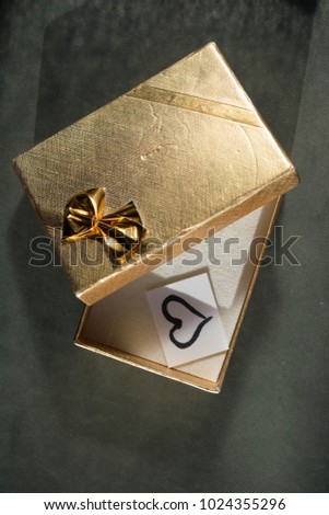 Gold gift box with a heart drawn on paper