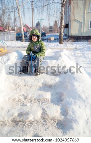 the boy sits on the steps atop a snowy mountain