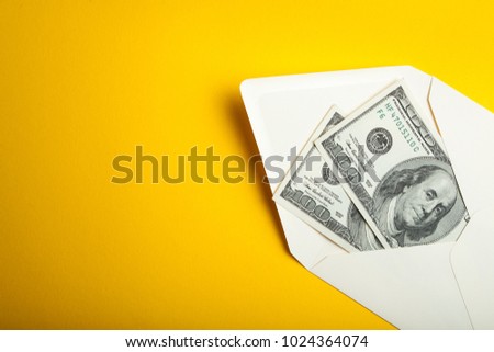 Dollars in an envelope on a yellow background.