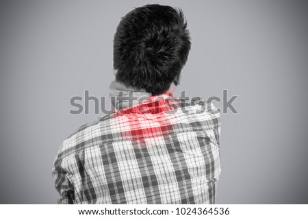 young man holding her back in pain. monochrome photo with red as a symbol for the hardening. isolated on gray background.