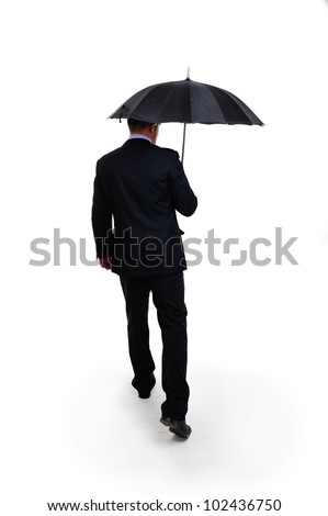 Business man in elegant modern suit holding an umbrella standing back
