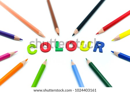 Close up Color pencils with Colorful wooden English alphabe on white background.
