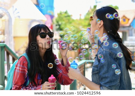 Travel Concepts. Beautiful girl is playing soap bubble fun. Asian girls are relaxing travels. Asian girls blowing bubbles into the air. Beautiful girl takes a break in playing bubble activities.