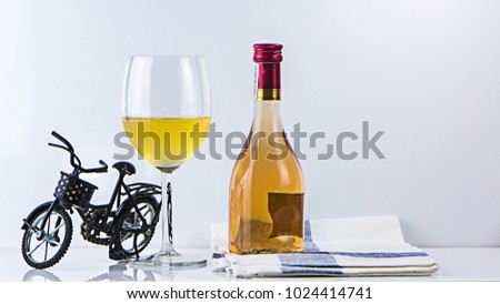 Wine. Bottle and glass of white wine with bike. White wine Over white background. Glass bottle of wine on white background. Border art design.