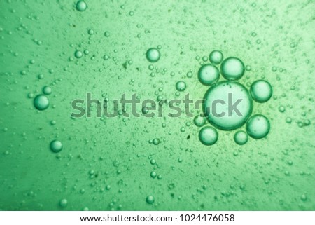Green oil bubbles on water surface