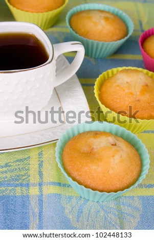 Cup of tea and cakes in the yellow and blue tablecloths