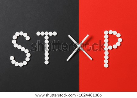 Medication white round tablets in word Stop. Creative composition with message Stop smoke cigarettes on red black background. Concept of health, choice, healthy lifestyle. Copy space advertisement