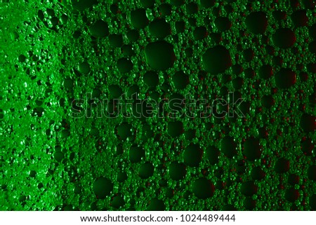 
green colorful small soap bubbles with backlight