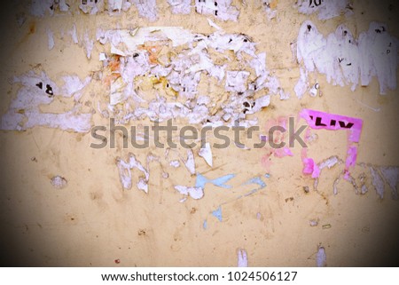Vintage Old Concrete Wall With Torn Ads Background Or Texture For Design. Grunge Plastered Urban Modern Wall With Stripped Paper Advertising. Peeled And Shabby Building Facade With Ragged Sti?kers