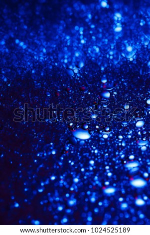 
blue feone neon drops under a microscope on glass