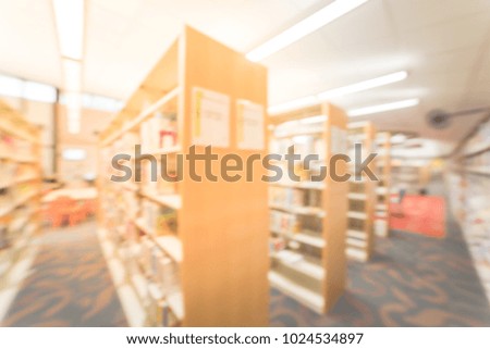 Blurred aisle of bookshelf with seating and faculties for reading at public library in America. continuing education concept.