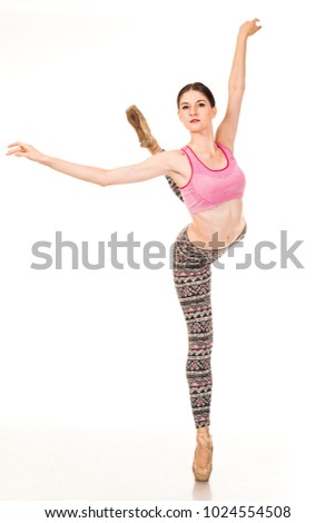 Beautiful slender ballerina in pointe shoes, posing in dance. Isolated photo on a white background. Shows different poses in ballet. Dressed in tights and pink top