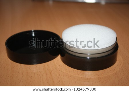 A black box with a white sponge on a brown table was photographed, choose a focus
